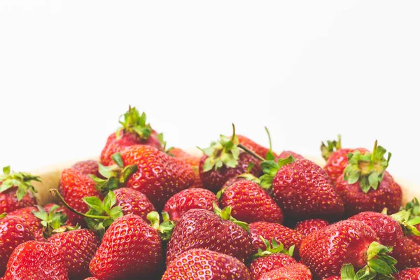 Fraises dans une assiette en bois sur fond blanc. — Photo