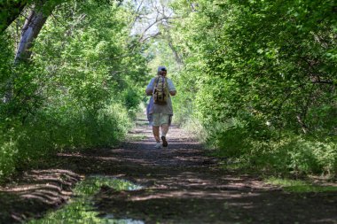 Sırt çantalı yaşlı bir kadın. Yürüyüş yapıyor..