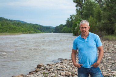 Kayalık nehir kıyısında bir adam.