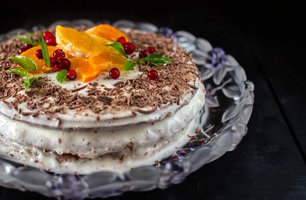 Торт украшен апельсинами, клюквой и зелеными листьями — стоковое фото