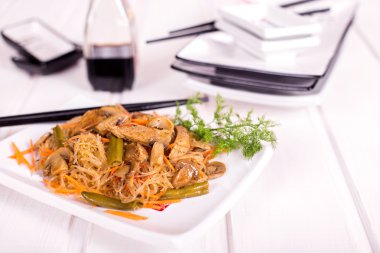 Tabak pirinç spagetti, mantar ve beyaz tabakta et