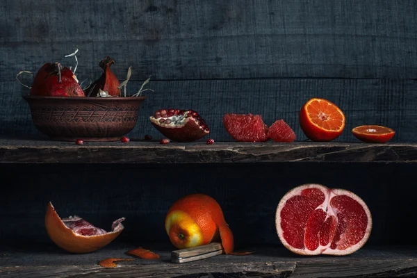 Owoce cytrusowe i granat na półkach, w stylu rustykalnym — Zdjęcie stockowe