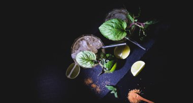 Siyah bir masada limonlu kokteyllerin düz konumu