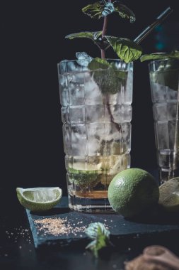 Nane ve limonlu siyah arka planda iki karamsar kokteyl.