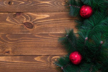 Süslü bir Noel ağacı dalına sahip ahşap bir arka plan. Yeni yıl konsepti. Uzayı kopyala Düz atış yapmak için masanın yüzeyi yatıyordu. Üst Manzara. Doğal ham planlı ahşap.