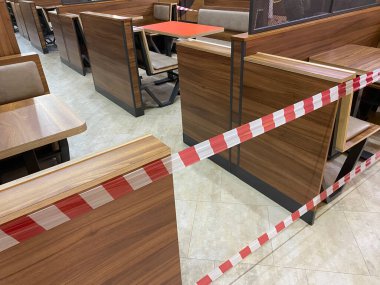 Alışveriş merkezinin yemek salonu karantinaya alınmıştır, koronavirüs tehdidi, restorana erişim, kafeye giriş salgın süresince yasaktır, koltuklar uyarı bandıyla kapatılmıştır.