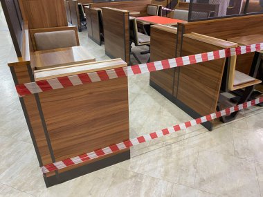 Alışveriş merkezinin yemek salonu karantinaya alınmıştır, koronavirüs tehdidi, restorana erişim, kafeye giriş salgın süresince yasaktır, koltuklar uyarı bandıyla kapatılmıştır