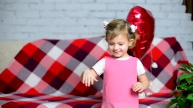 Küçük güzel kız kalp şeklinde pembe bir balonla oynuyor. Sevgililer Günü tatili. Çocuklar buna bayılır. Mutlu çocuk doğum gününü kutlar, kadınlar ve anneler gününü kutlar..