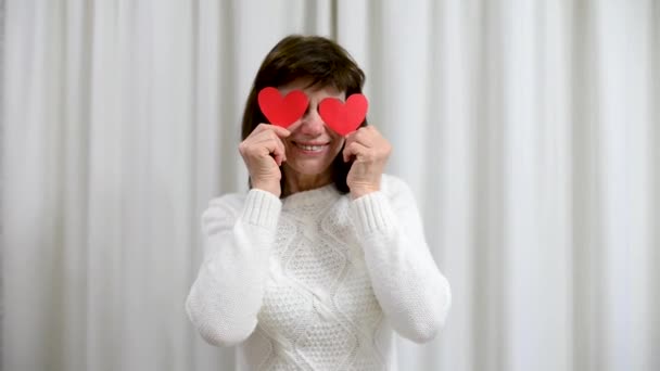Verrückte erwachsene Senioren feiern Valentinstag. Frauen bedecken die Augen mit roten Valentinskarten und lächeln. Romantische Beziehungen, Liebe und Dating im Ruhestand. Lebensstil älterer Menschen. — Stockvideo