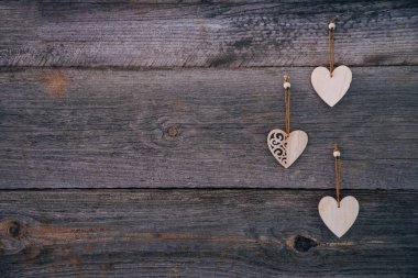 Sevgililer Günü geçmişi. Kahverengi doğal tahtalar, grunge stili, üç tahta kalpli. Üst Manzara. Flatlay çekmek için masanın yüzeyi. Aşk kavramı, romantik ilişki. Metin için alanı kopyala.