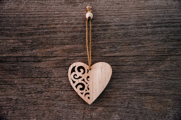 Valentijnsdag achtergrond. Bruine natuurlijke planken in grunge stijl met een houten decoratieve hartjes. Bovenaanzicht. Oppervlakte van de tafel om plat te schieten. Concept liefde, romantische relatie. — Stockfoto