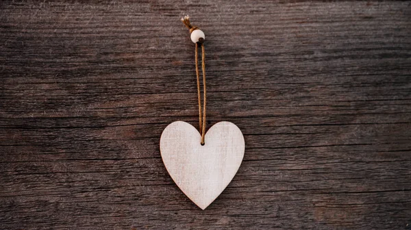 Valentijnsdag achtergrond. Bruine natuurlijke planken in grunge stijl met een houten decoratieve hartjes. Bovenaanzicht. Oppervlakte van de tafel om plat te schieten. Concept liefde, romantische relatie. Banner. — Stockfoto