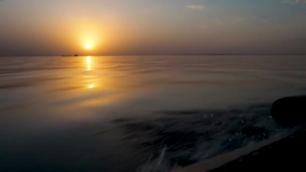 Золотой закат во время водной прогулки на моторной лодке на большой скорости. Красивый живописный пейзаж. Отражение оранжевого солнца рассвета на волнах. Тряска и подача. Возвращение с вечерней рыбалки. — стоковое видео