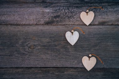 Sevgililer Günü geçmişi. Kahverengi doğal tahtalar, grunge stili, üç tahta kalpli. Üst Manzara. Flatlay çekmek için masanın yüzeyi. Aşk kavramı, romantik ilişki. Metin için alanı kopyala.