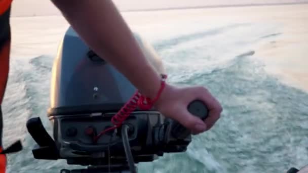 身穿救生衣的人驾驶着一条机动橡胶充气船 手和引擎的特写 我在计划浪涌上水面 高速乘船旅行 自由和行动的概念 钓鱼之旅 — 图库视频影像