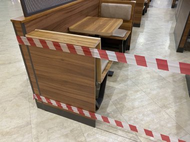 Alışveriş merkezinin yemek salonu karantinaya alınmıştır, koronavirüs tehdidi, restorana erişim, kafeye giriş salgın süresince yasaktır, koltuklar uyarı bandıyla kapatılmıştır