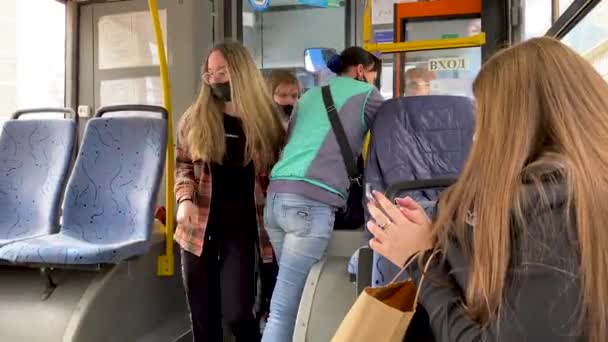 보호용 마스크를 쓰고 있는 소녀들은 버스에 들어가 여비를 지불 한다. 전염병 이 창궐하는 동안 대중교통을 이용한다. 새로운 평범 함. 버스 승객들은 보호받는다. 러시아, 볼고돈스크 2021 년 4 월 28 일. — 비디오