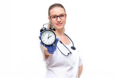 Beyaz önlüklü kadın doktor elinde nöbet tutuyor. Sağlığınla ilgilenme zamanı. Beyaz arka planda izole edilmiş. Doktora zamanında erişim, tıbbi muayeneleri geçme, hastalıkların önlenmesi..