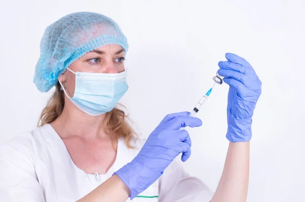 防護マスクと手袋の女性医師が注射器にワクチンを打ってる。接近中だ。バイオロジスト科学者。インフルエンザ、ウイルスのパンデミック、コロナウイルスに対する予防。人々の必須予防接種. — ストック写真