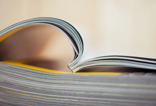 Open magazine sitting on a stack — Stock Photo, Image