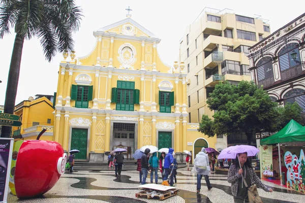 Cityscape of Macau, people are walking. Located in St. Dominic's Church, Macau. It is a Historic Centre of Macau, a UNESCO World Heritage Site. It's rainy season. — Stock Photo, Image