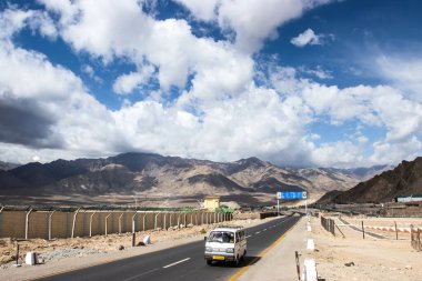 LEH, Hindistan - 16 Haziran 2019: Hindistan 'ın kuzeyinde Leh-Ladakh' ta dağ ve gökyüzü arka planına sahip Leh karayolu kırsal yol manzarası