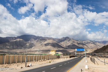 LEH, Hindistan - 16 Haziran 2019: Hindistan 'ın kuzeyinde Leh-Ladakh' ta dağ ve gökyüzü arka planına sahip Leh karayolu kırsal yol manzarası