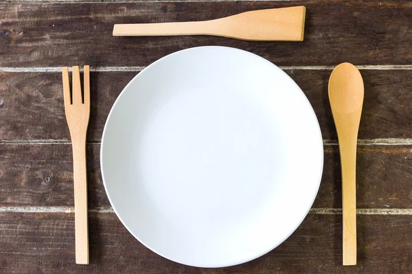 Wooden fork and spoon and empty plate — Stock Photo, Image