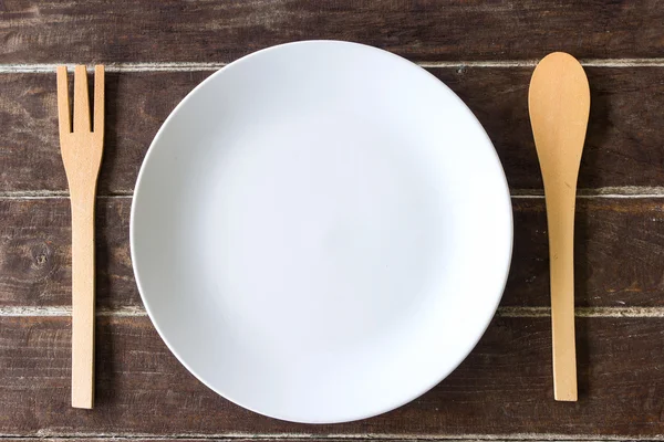 Forchetta e cucchiaio in legno e piatto vuoto — Foto Stock