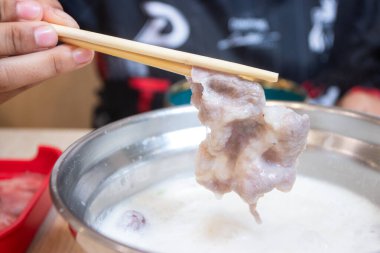 Pişmiş et, çubuklarla kaynamış sıcak bir tencerede süt beyazı çorbası ile tutulur. Shabu-shabu ya da Asya sukiyaki yemek kavramları için ideal..