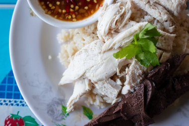 Buharda pişirilmiş tavuk göğsü, kan tofusu ve baharatlı sos ile Hainanese tavuğu pilavı. Tayland sokak yemeği..