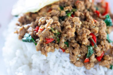 Baharatlı Tayland fesleğeni, kıyılmış domuz ve kırmızı biberli, geleneksel bir sokak yemeği olan buharda pişirilmiş yasemin pilavı..