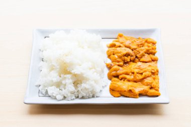 Beyaz tabakta yasemin pilavlı taze deniz kestanesi (uni) ve siyah bir kâsede kavrulmuş Norveç yosunu, birinci sınıf Japon lezzeti..