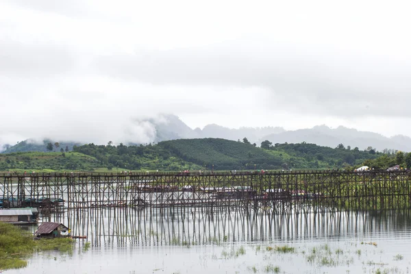 Raveler crossing bamboo bridge or Mon Bridge in Sangklaburi. Kanchanaburi, Thailand. — Stock Photo, Image