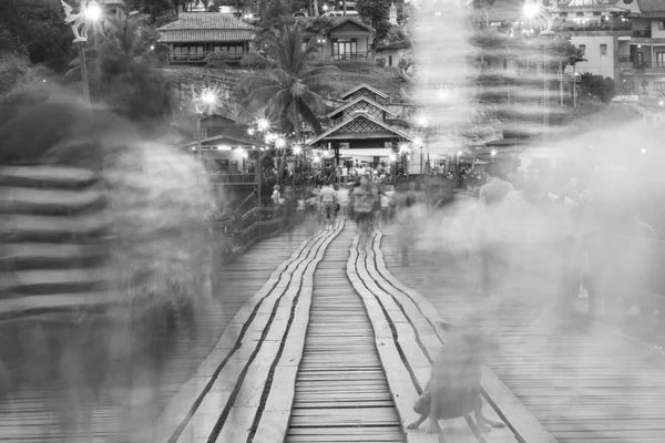 Černá a bílá rozostření obrazu cestovatel křížení bambusové most nebo Mon most v Sangklaburi. Kanchanaburi, Thajsko. — Stock fotografie