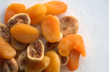 Beyaz arka planda kurutulmuş incir ve kayısılar.