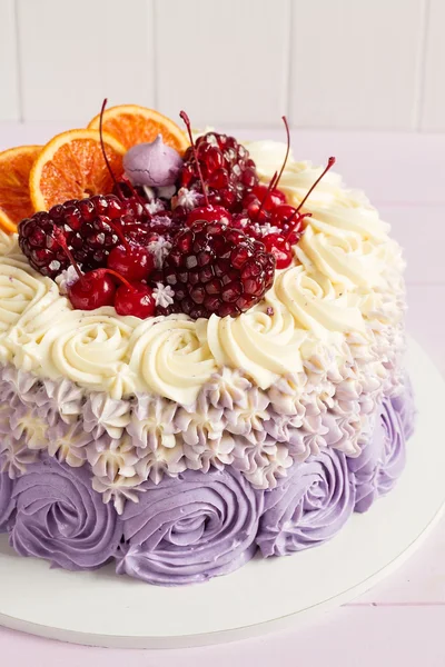 Elegant purple rosette cake decorated with fruit — Stock Photo, Image