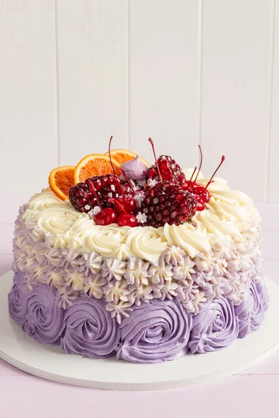 Elegant purple rosette cake decorated with fruit — Stock Photo, Image