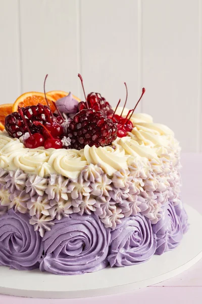 Elegant purple rosette cake decorated with fruit — Stock Photo, Image