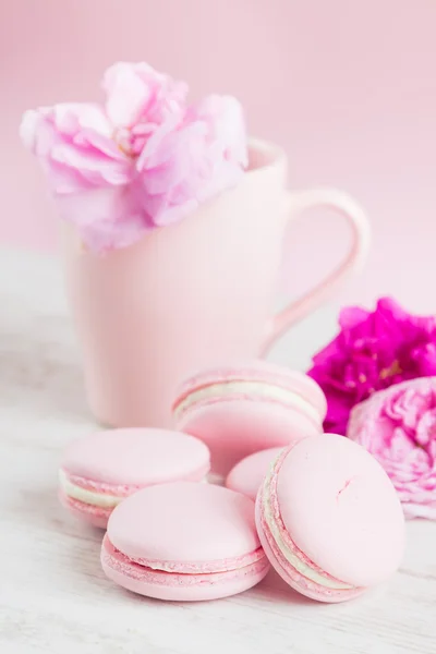 Pastel pink macaroons and tea cup with rose — Stock Photo, Image