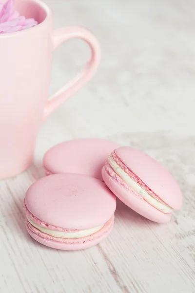 Macaroons rosa macio no fundo de madeira branca — Fotografia de Stock