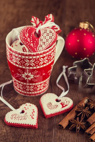 Biscotti di pan di zenzero a forma di cuore sulla tazza rossa con decorazioni natalizie — Foto Stock