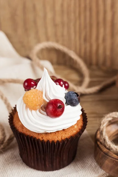 Sommer-Cupcake mit Schlagsahne und Früchten auf hölzernem Hintergrund — Stockfoto