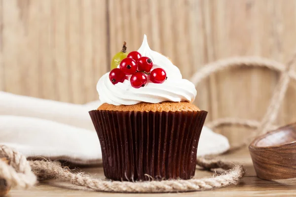 Sommer-Cupcake mit Schlagsahne und Früchten auf hölzernem Hintergrund — Stockfoto