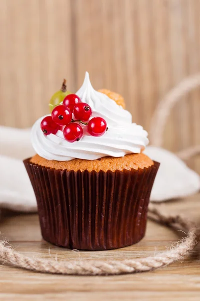 Sommer-Cupcake mit Schlagsahne und Früchten auf hölzernem Hintergrund — Stockfoto