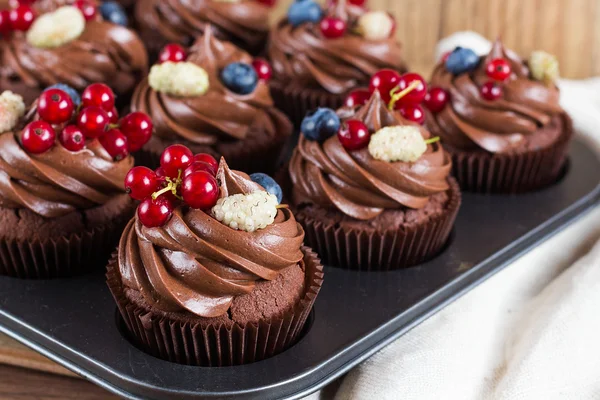 Schokoladen-Cupcakes mit Schokoladencreme und Sommerblumen dekoriert — Stockfoto