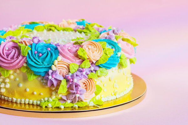 Bright colorful cake decorated with cream flowers