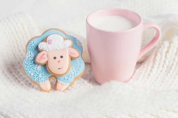 Blue gingerbread sheep with cup of milk on white knitted backgro — Stock Photo, Image