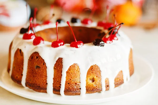 Застекленный торт с белой глазурью на рождественском фоне — стоковое фото
