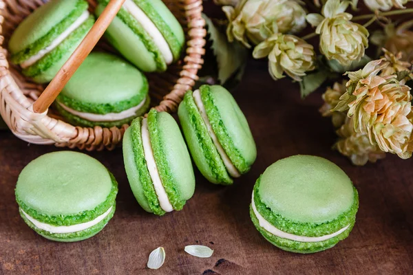 Macaroons verdes em fundo de madeira escura — Fotografia de Stock